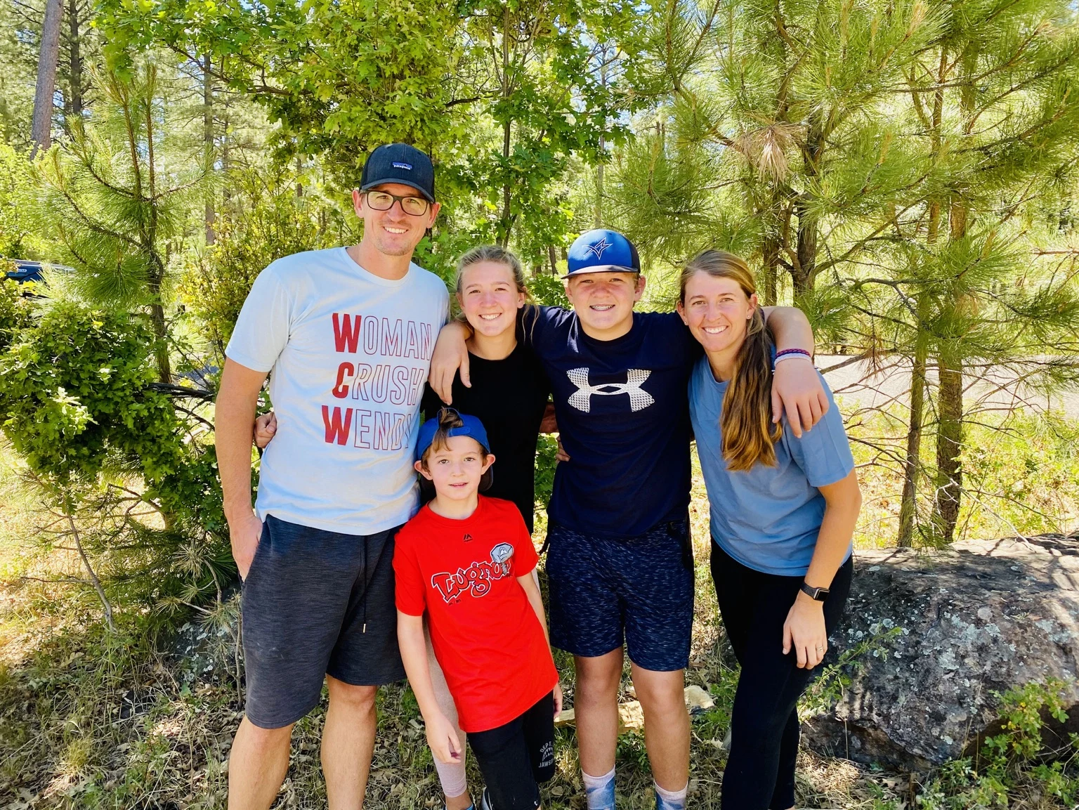 The Harwood family posing together among trees on a day outdoors