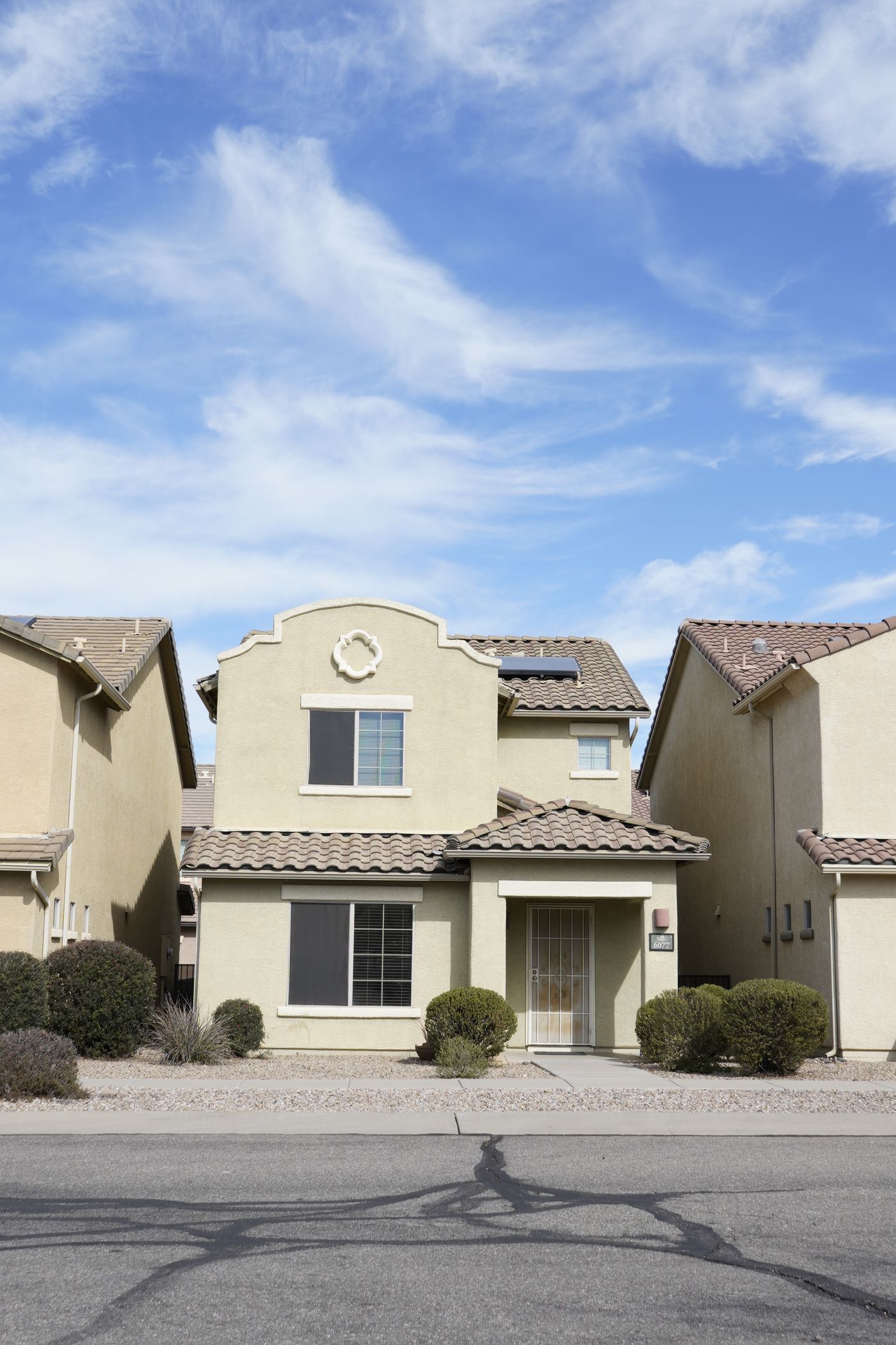 A Tucson stucco home with a tile roof and desert landscaping
