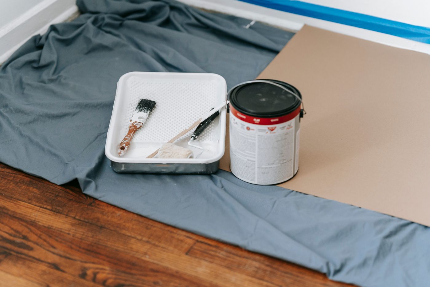 Paint, rollers and protective coverings prepared for an interior refresh