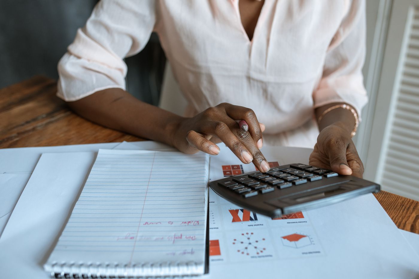 A professional reviewing financial records with a calculator