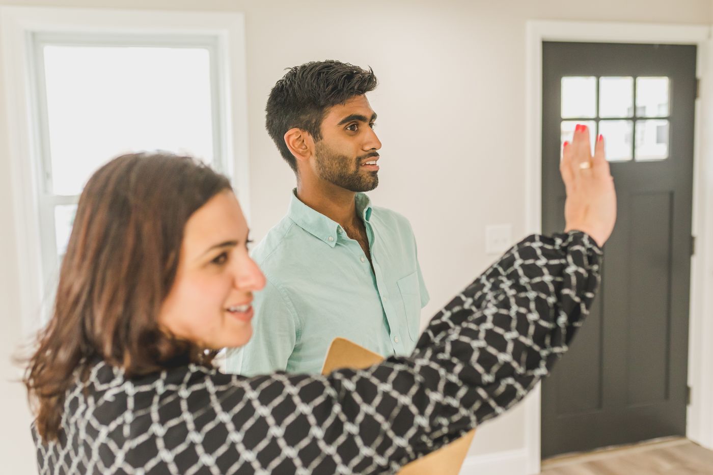 A real estate professional and client walking through a light-filled home
