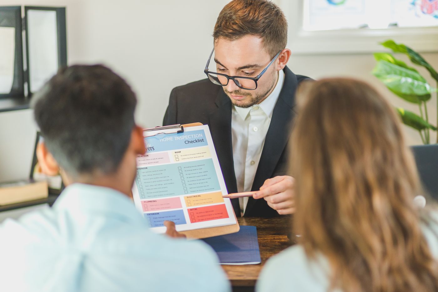 A couple reviewing a document with a property professional