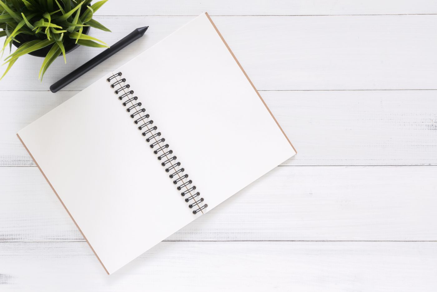 An open notebook and writing supplies on a clean desk