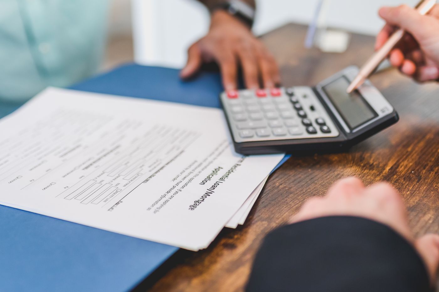 Hands reviewing property costs with a calculator and documents