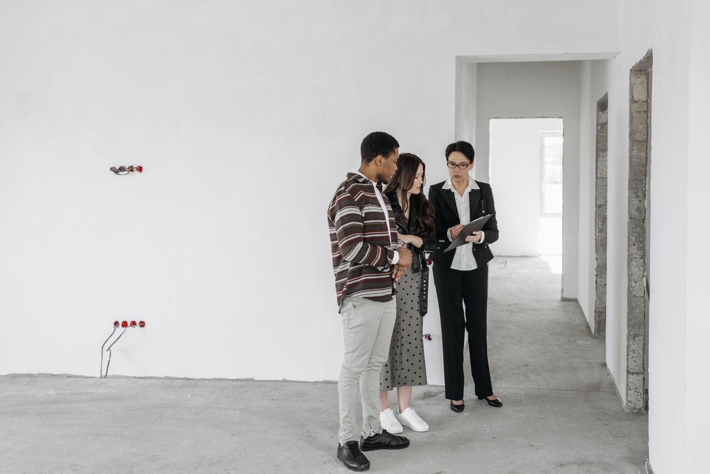 A couple reviewing plans with a property professional inside an unfinished home
