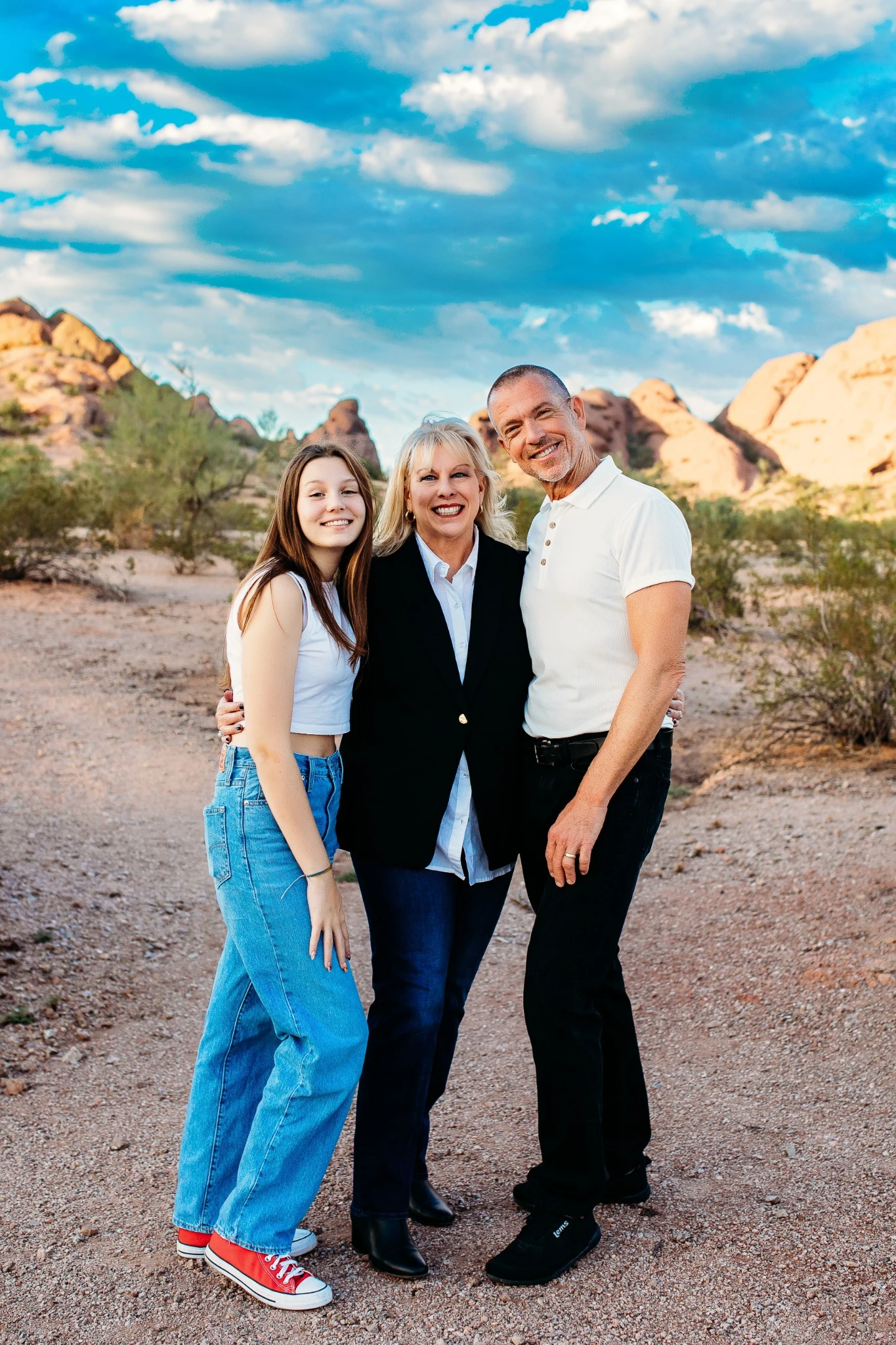 Reese, Judy and Paul smiling together among Arizona desert rocks